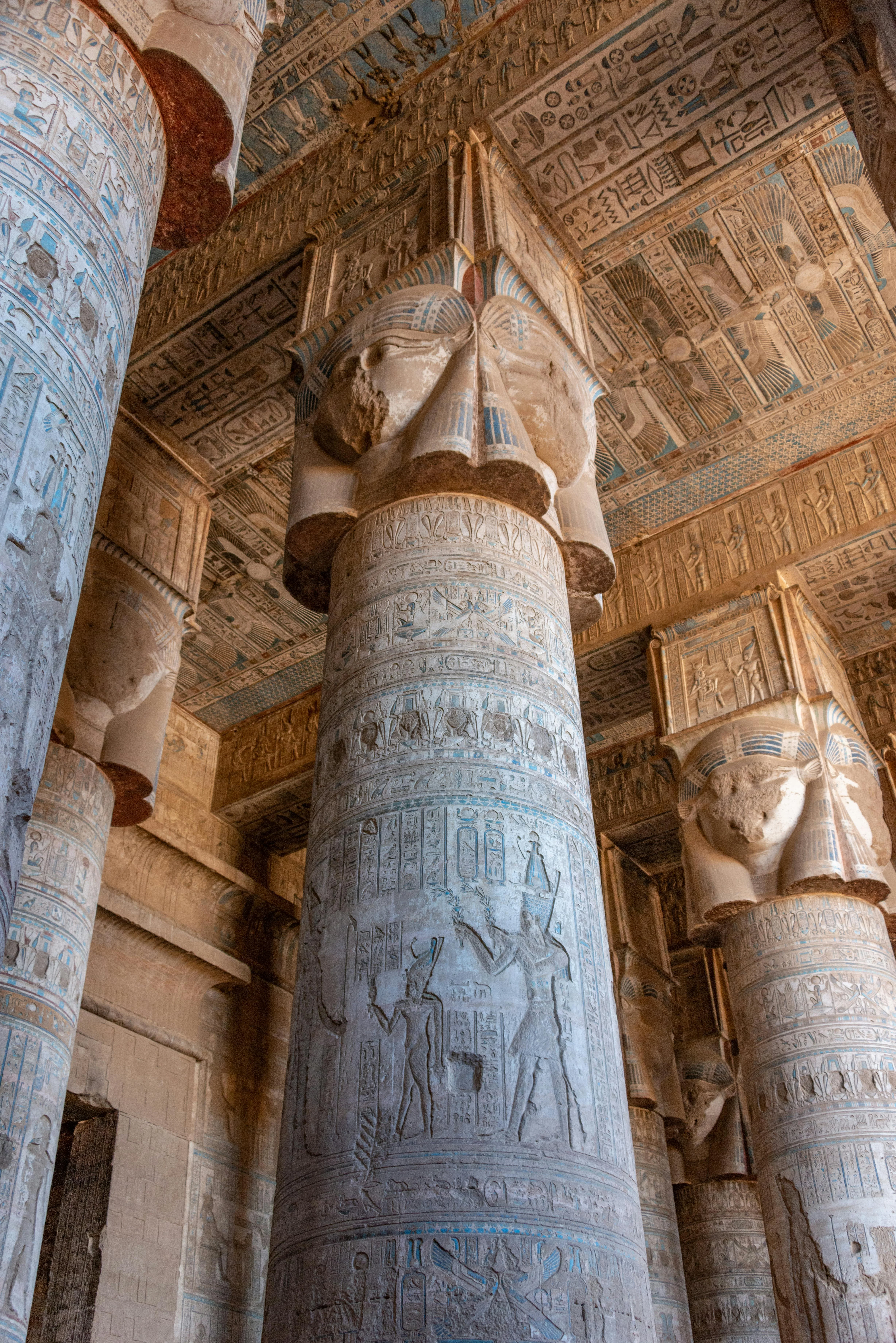 Deeply carved hieroglyphics and vibrant original colors on the massive walls of Medinet Habu Temple.